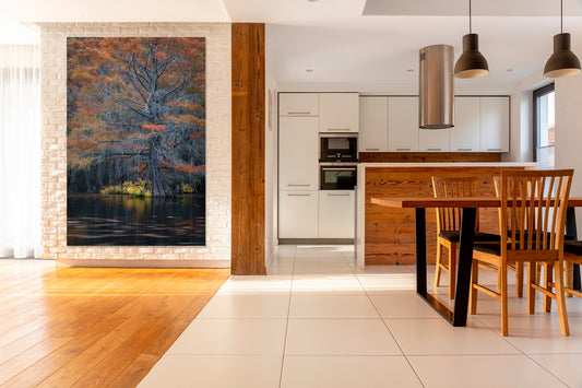 Modern kitchen with wooden dining table and chairs, artwork on the wall.