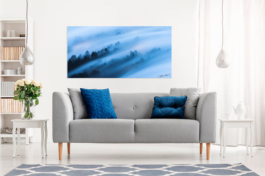 Living room with a gray sofa, blue pillows, and a large abstract photo on the wall.