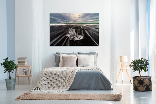 Modern bedroom with a large photograph of a black sand beach on the wall