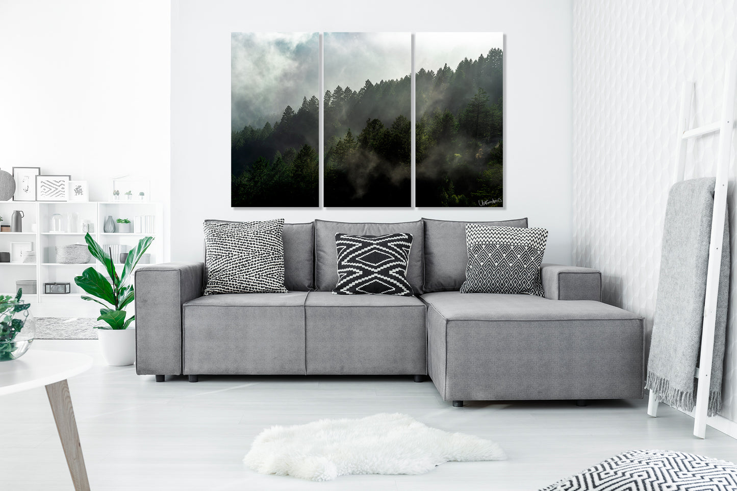 Gray sectional sofa with patterned cushions in a modern living room setting with large multiple panel artwork.