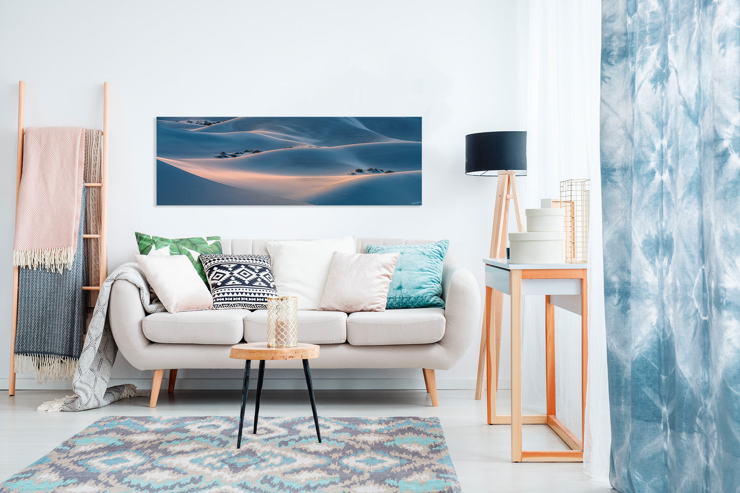 Modern living room with a sofa, coffee table, and a panoramic photograph.