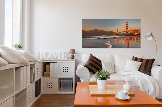 Modern living room with a white sofa, orange coffee table, and a large photograph of the Golden Gate Bridge.