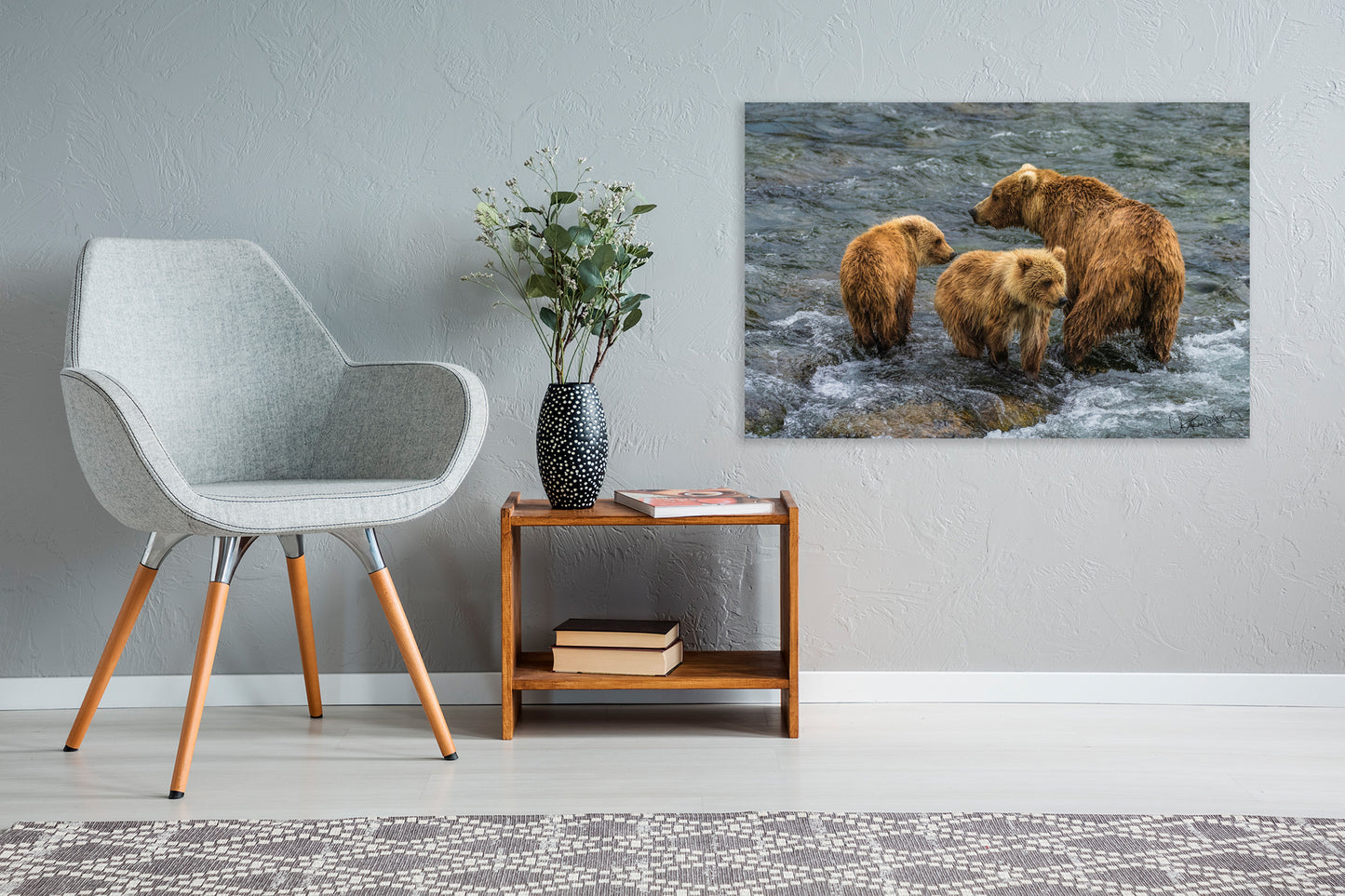 Living room with a gray chair, wooden side table, and a wall art of bears in a river.
