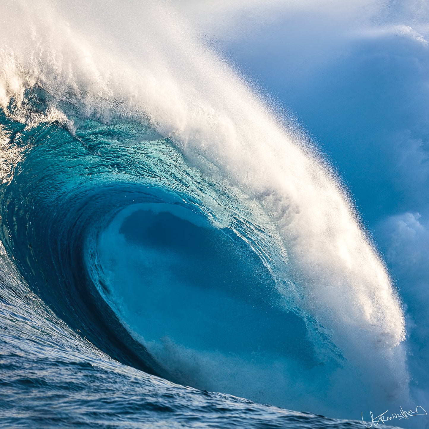 Powerful blue ocean wave with white foam against a clear sky