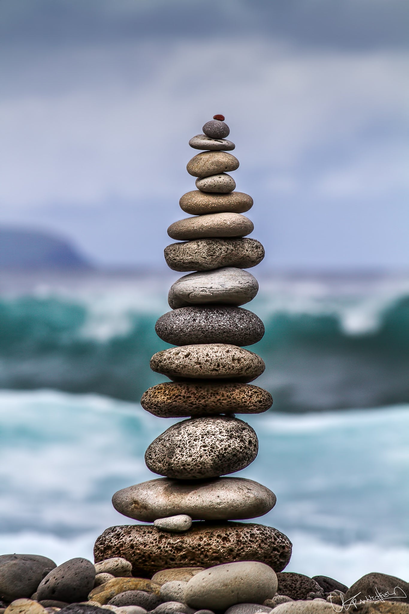 Stack of stones on a beach with ocean waves in the background