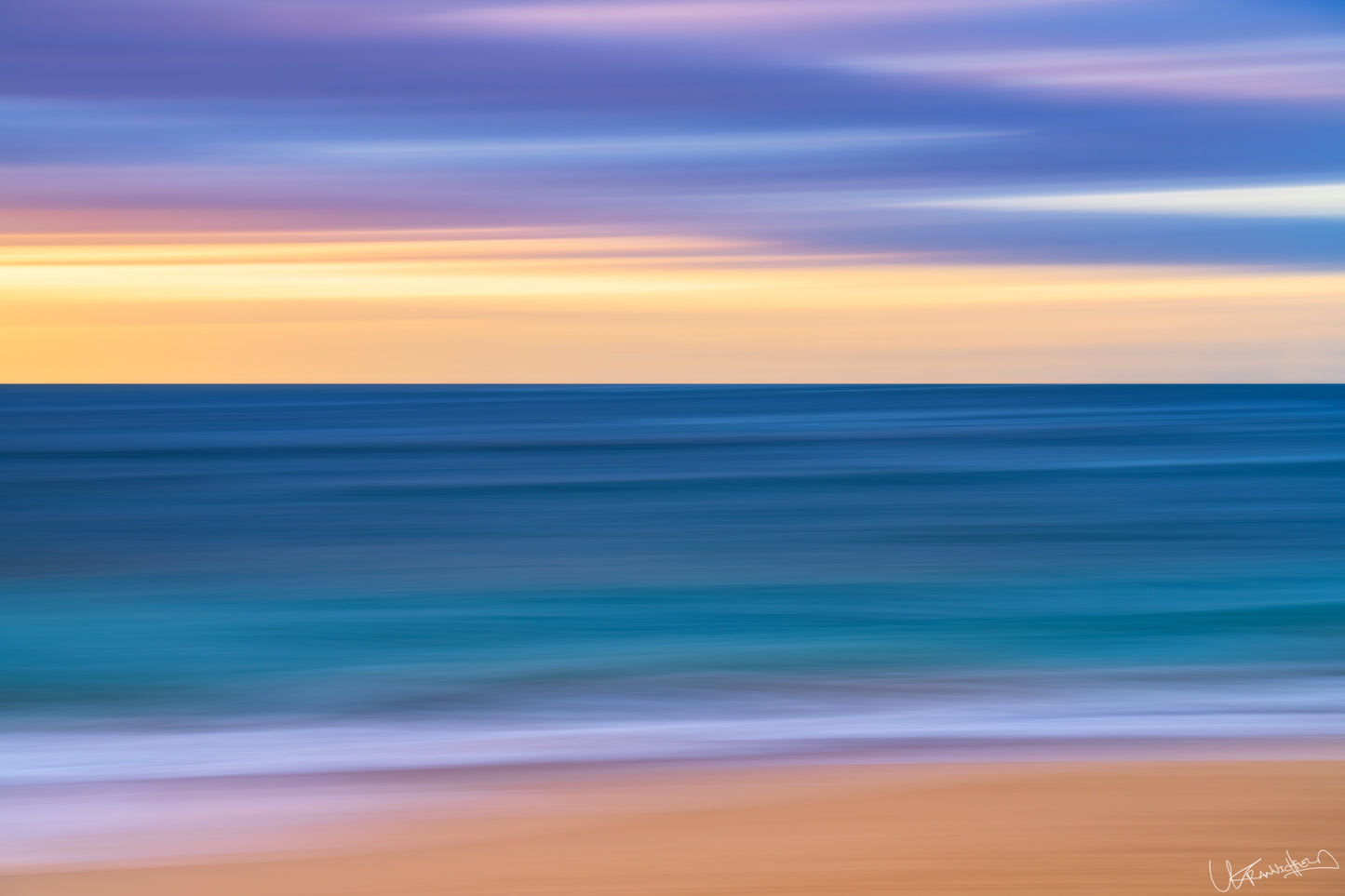Abstract seascape with blurred water and sand at sunset or sunrise.