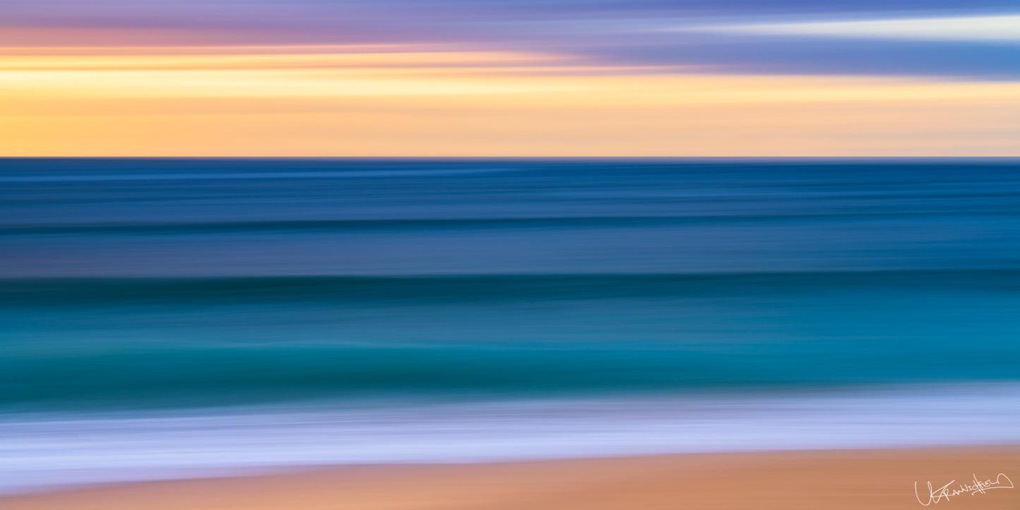 Abstract artwork with horizontal stripes of blue, purple, and yellow on a beach.