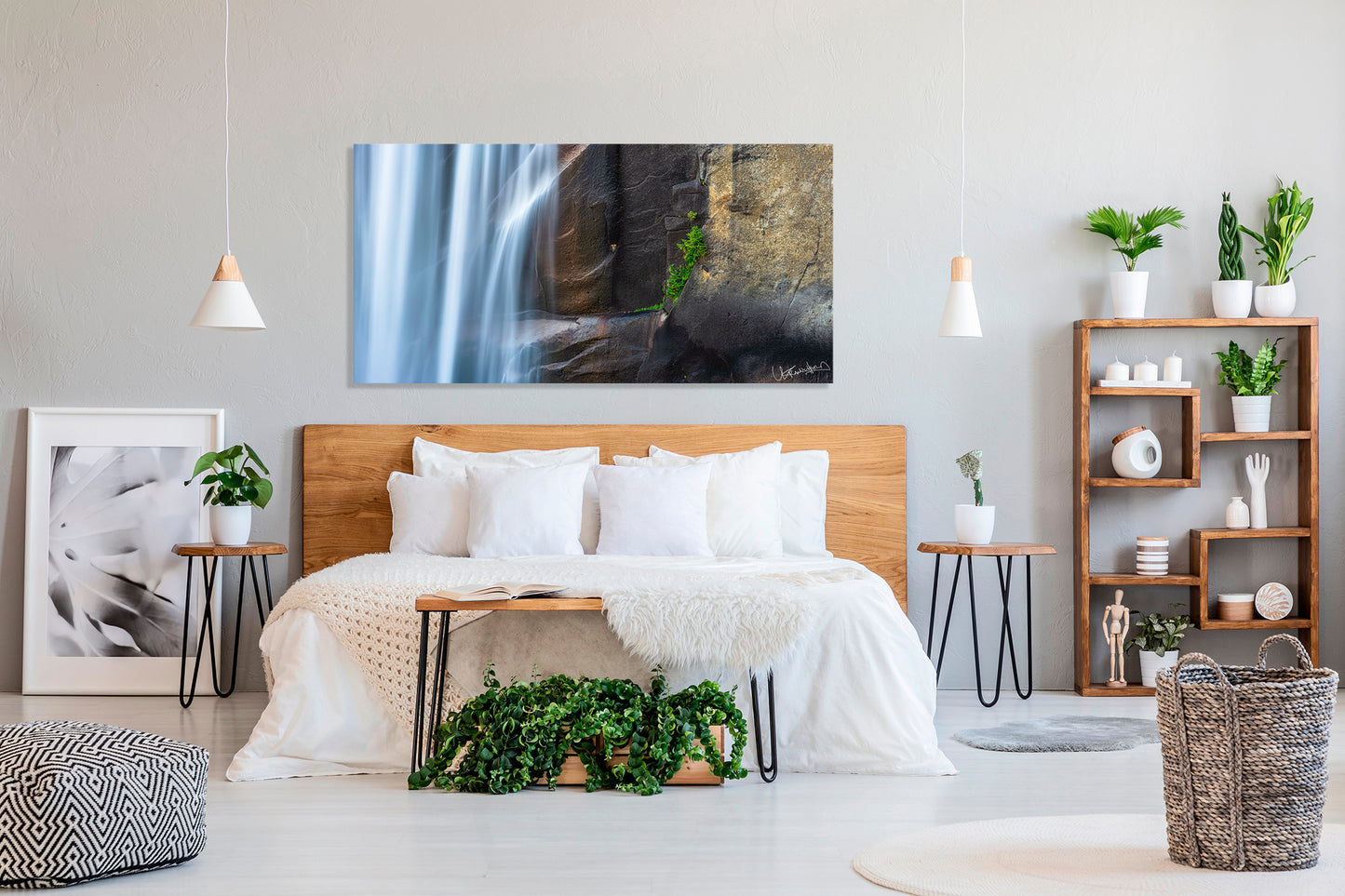 Modern bedroom with a large bed, decorative plants, and wall art.