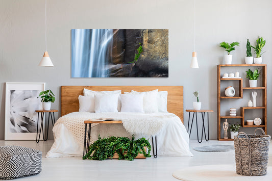 Modern bedroom with a large bed, decorative plants, and wall art.