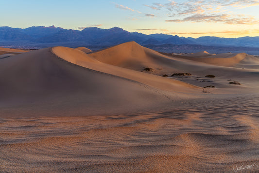 Desert landscape with sand dunes and mountains in the background