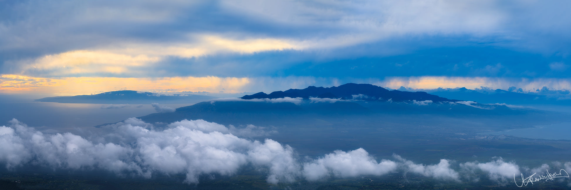 A panoramic image capturing a scenic view of clouds and mountains, taken from an elevated position near Haleakala National Park.