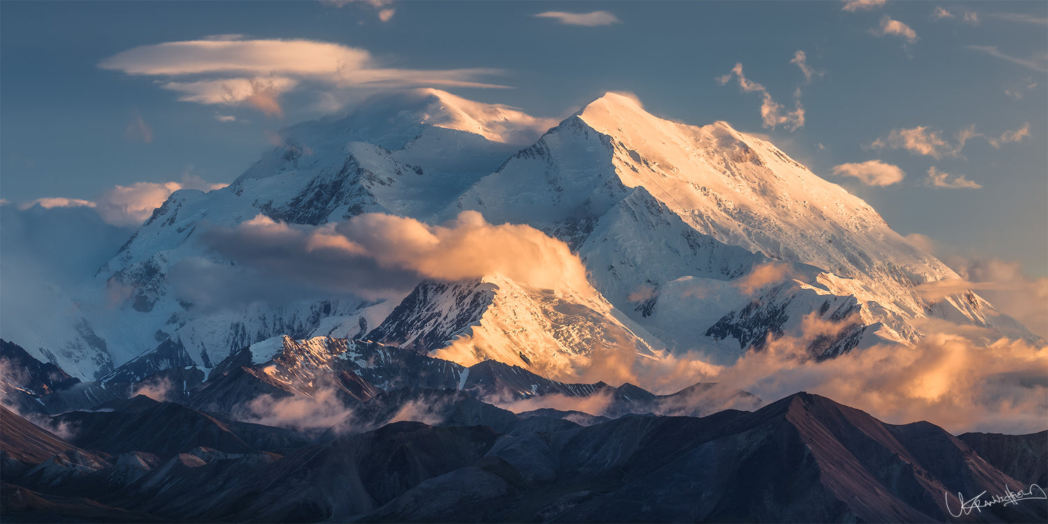 Snow-capped mountain peaks with clouds at sunset
