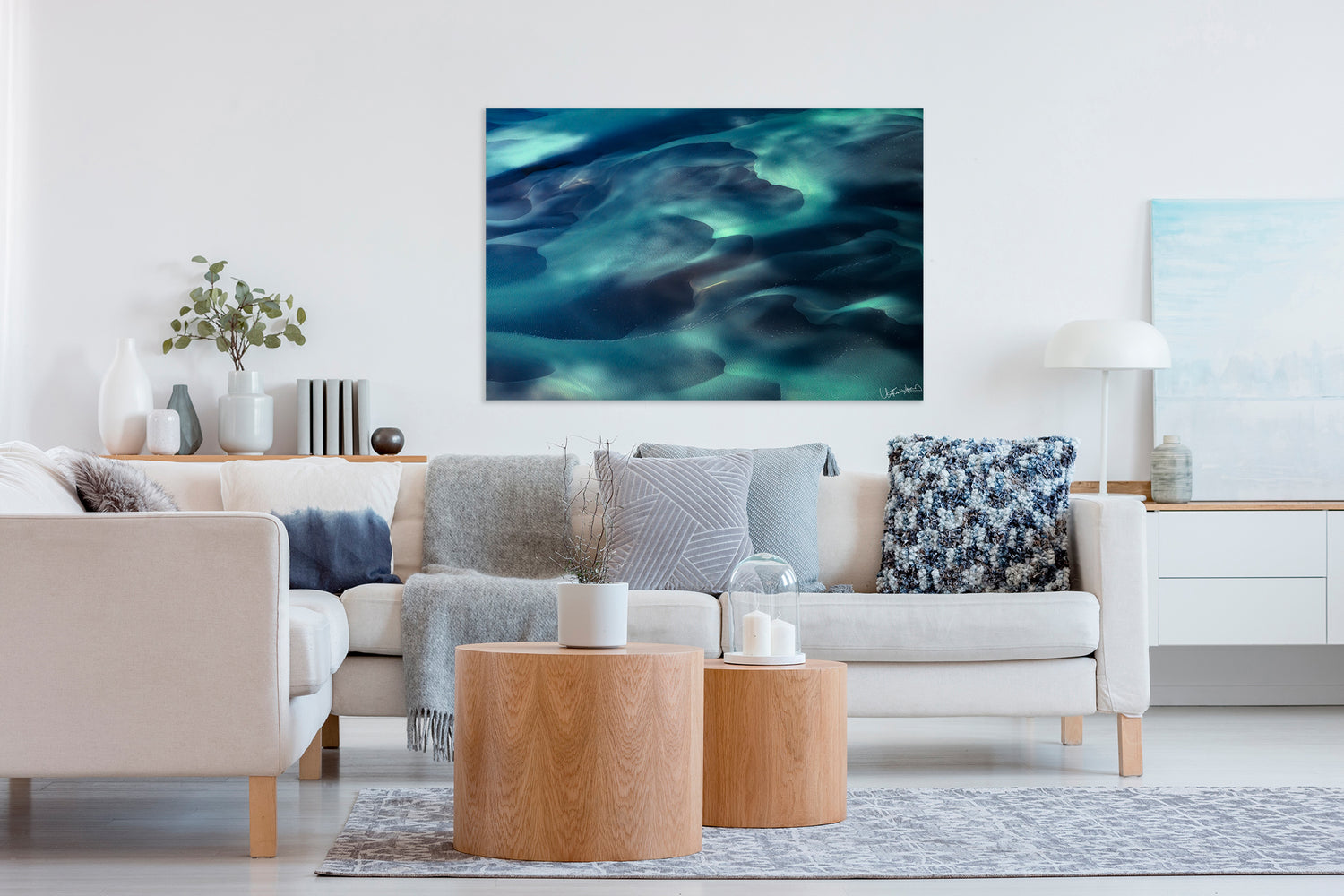 Living room with a large abstract painting on the wall, beige sofa, and wooden coffee table.