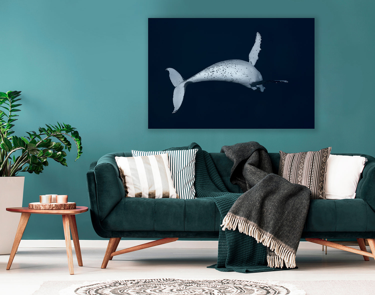 Living room with teal sofa, decorative pillows, and a large whale photograph on the wall.