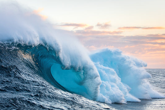 Large ocean waves crashing together with a sunset sky.