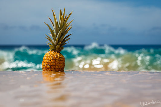 Pineapple on a beach with ocean waves in the background