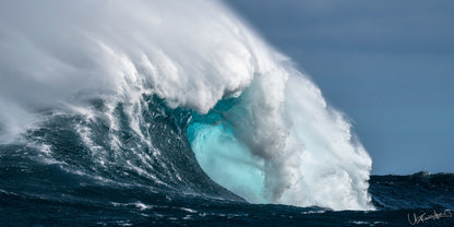 A large, powerful wave breaking in the ocean, capturing the fury of the sea with white foam and dark waters.