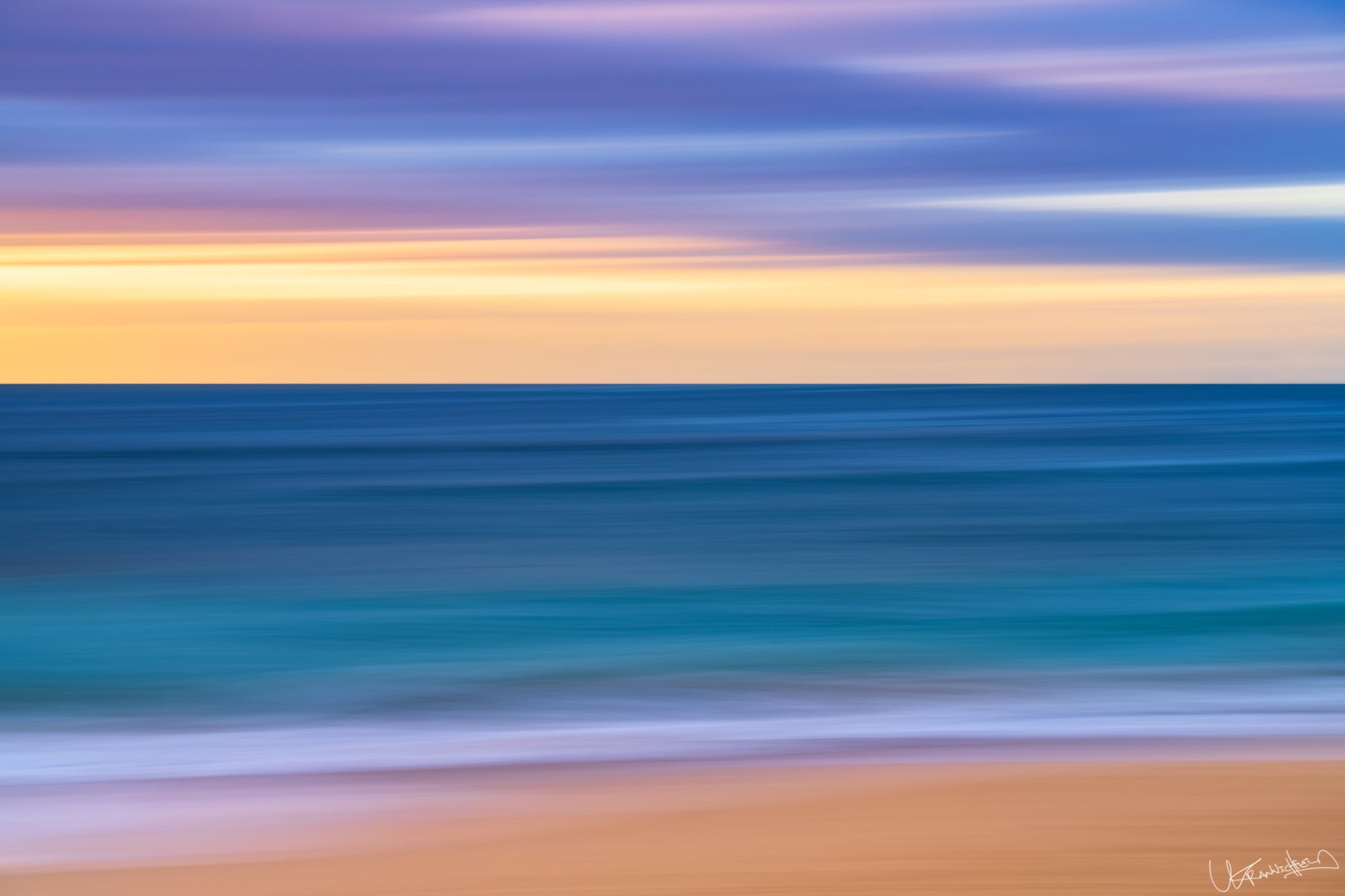 Abstract seascape with blurred water and sand at sunset or sunrise.