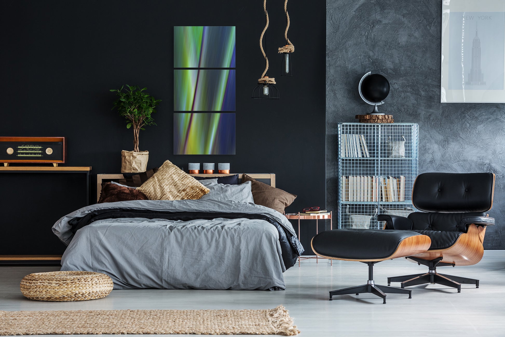 Modern bedroom with dark walls, a bed, and contemporary multi piece artwork.